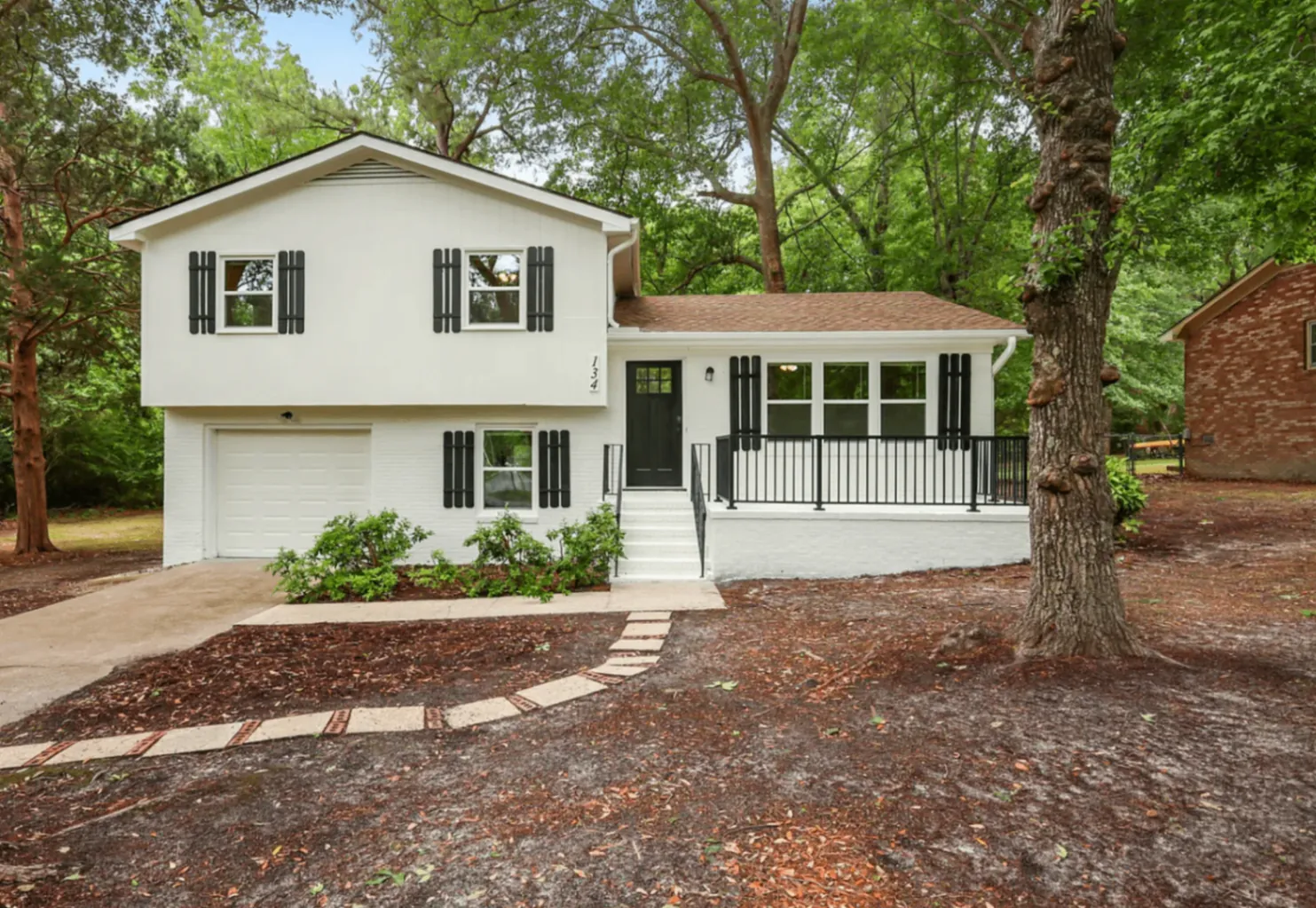 Front exterior of 134 S Channel Haven Drive S framed by mature trees
