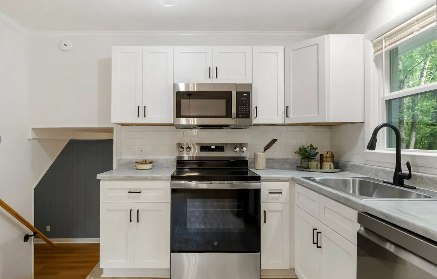 Updated eat-in kitchen with white cabinetry and stainless appliances
